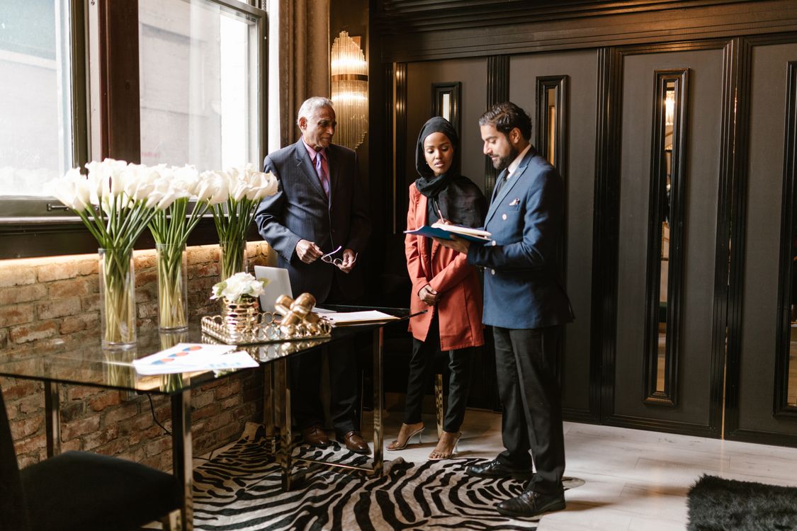 Trois professionnels échangeant dans le hall d’un hôtel