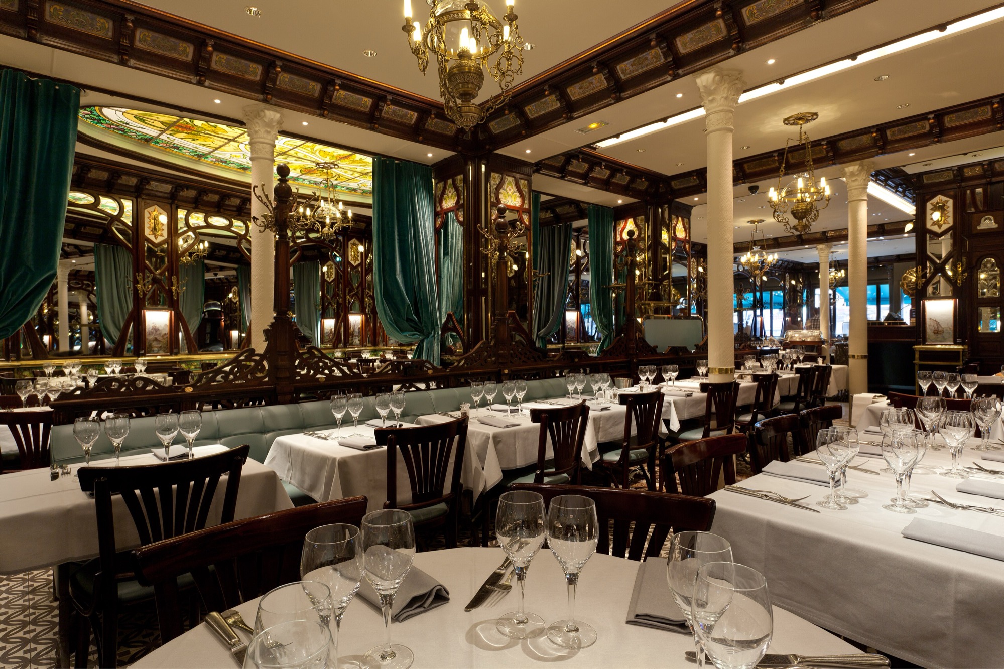 Salle d’une brasserie parisienne dressée avant le service